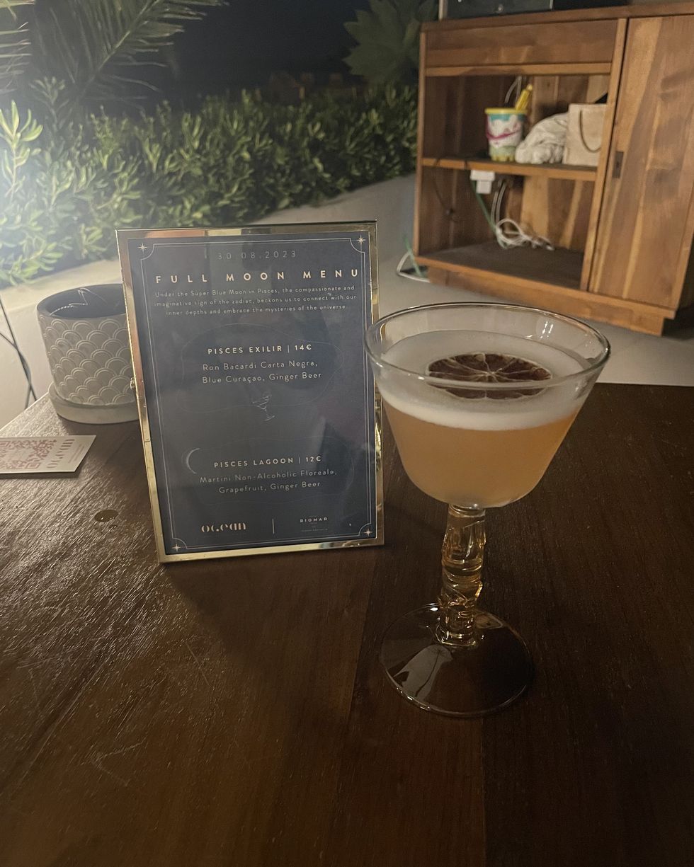 a cocktail and a sign on a table
