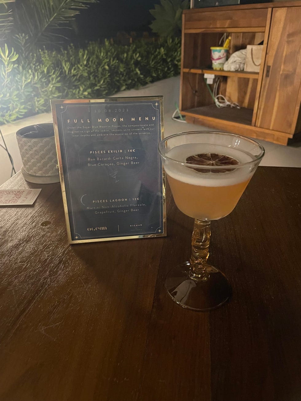 a cocktail and a sign on a table