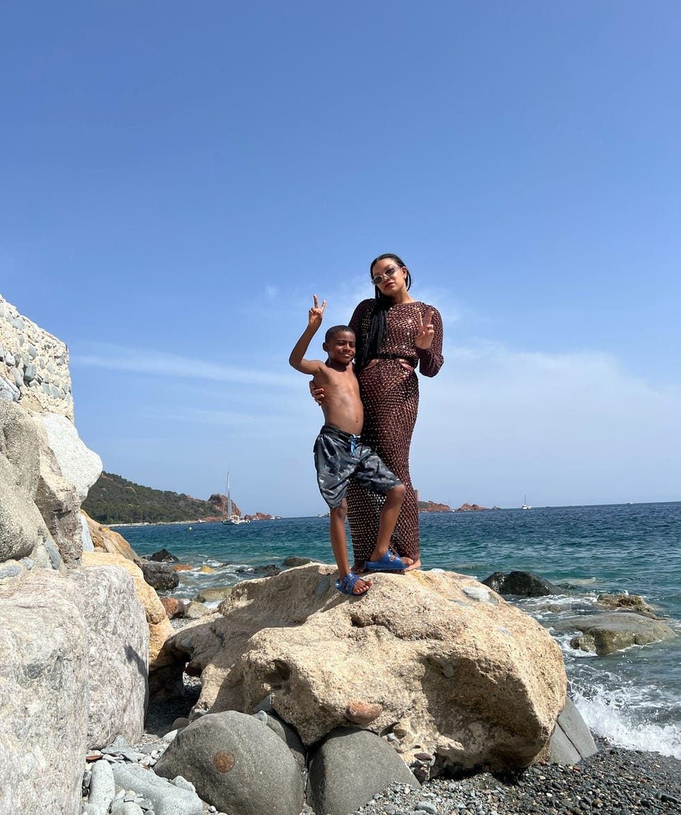 a man and a boy standing on rocks by the water