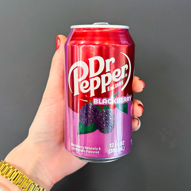 can of dr pepper blackberry held in a hand against a dark background