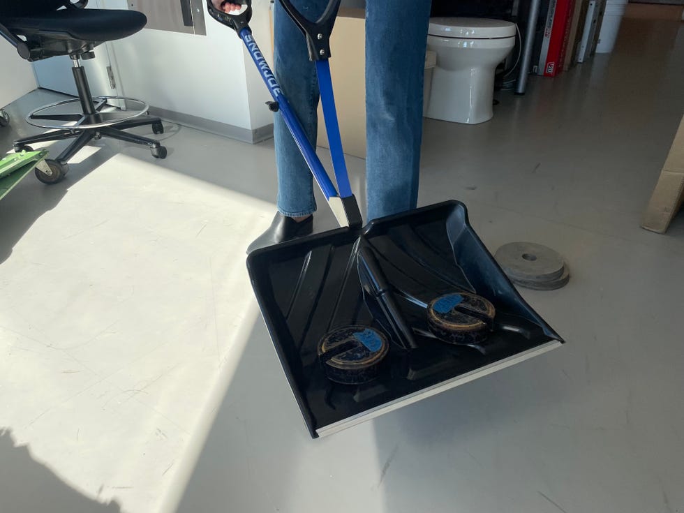 a tester uses weights to assess the durability of a snow shovel