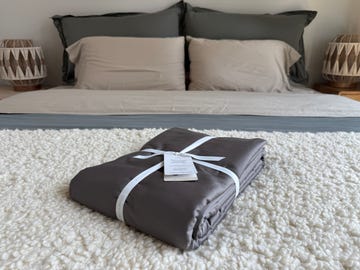 packed bedding set on a textured rug in a styled bedroom