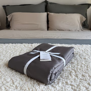 Packed bedding set on a textured rug in a styled bedroom packed bedding set on a textured rug in a styled bedroom