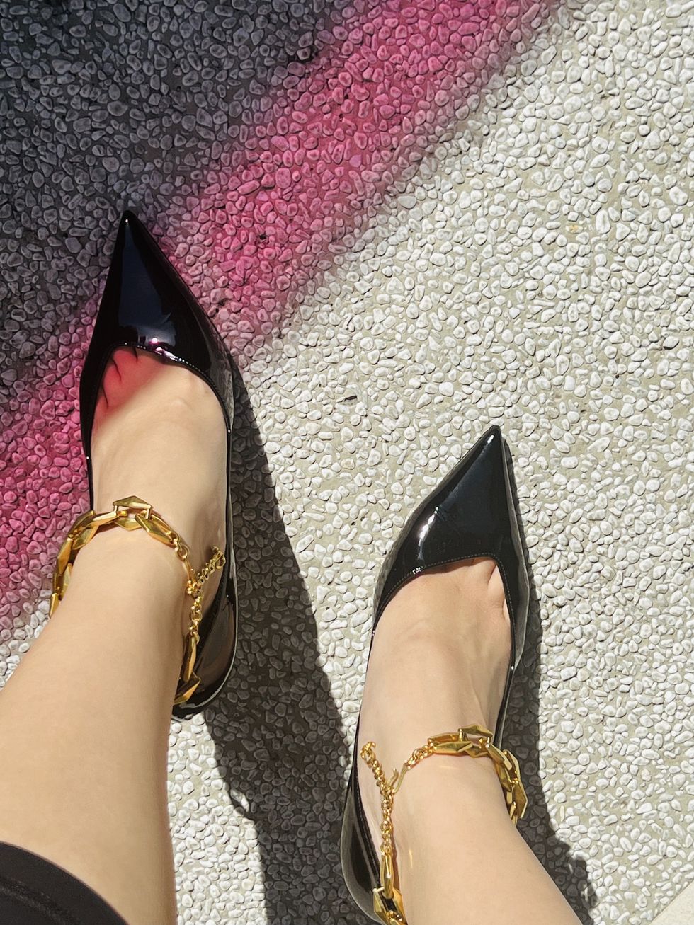 a pair of feet with gold sandals