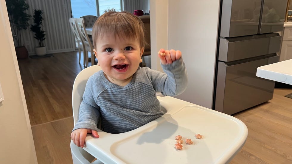 child sitting in a high chair testing out yumi meltable puffs