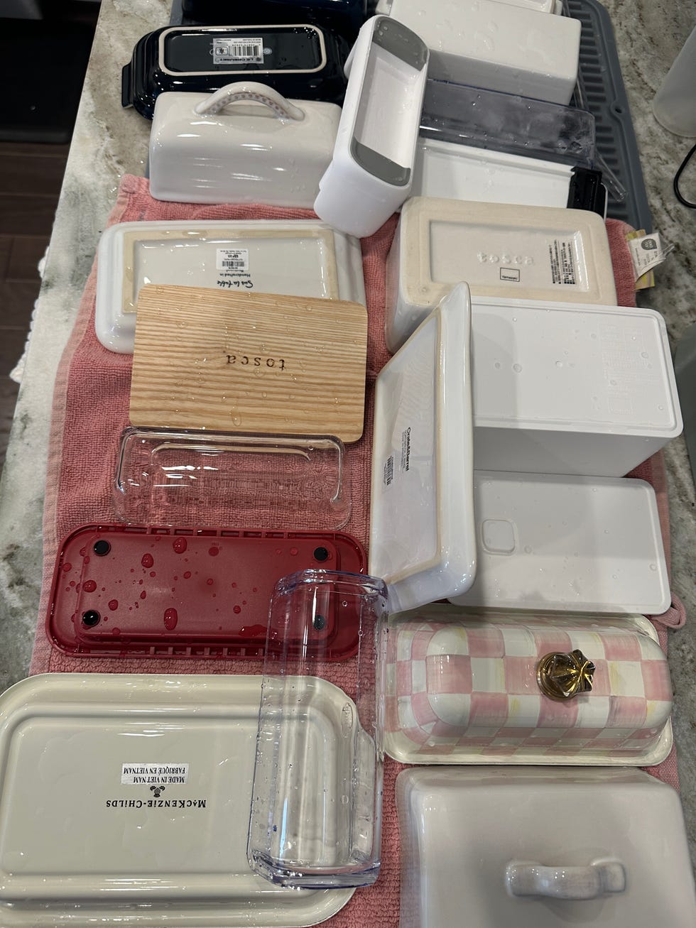 various food storage containers arranged on a kitchen counter with water droplets