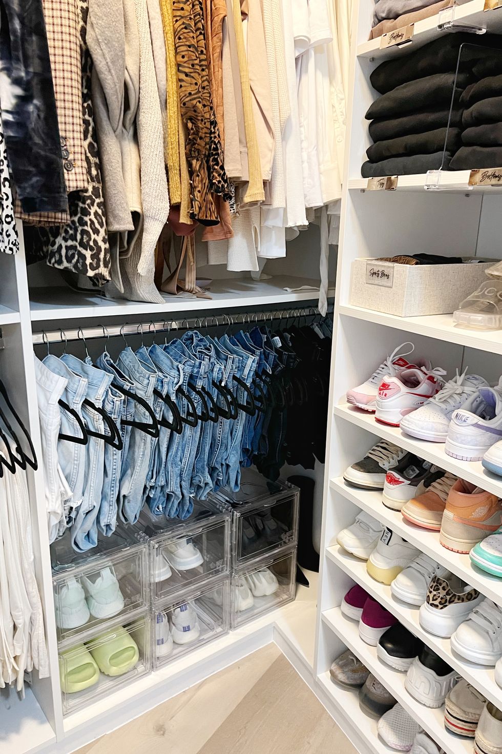 closet with hanging jeans and sneakers