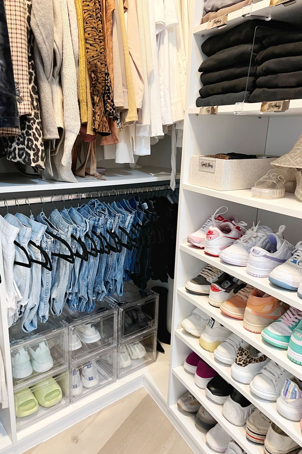 closet with hanging jeans and sneakers