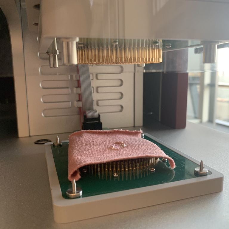 a close up shot of our moisture management tester with a fabric swatch that is failing to wick away droplets of a synthetic sweat solution