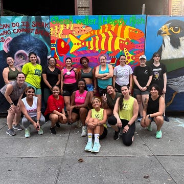 group of individuals posing in front of colorful mural featuring animals and a quote about speaking for those who cannot group of individuals posing in front of colorful mural featuring animals and a quote about speaking for those who cannot