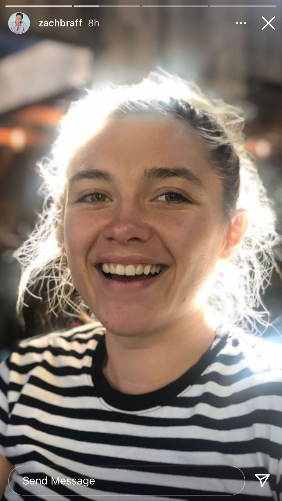 a portrait picture of florence pugh in a black and white striped t shirt, smiling