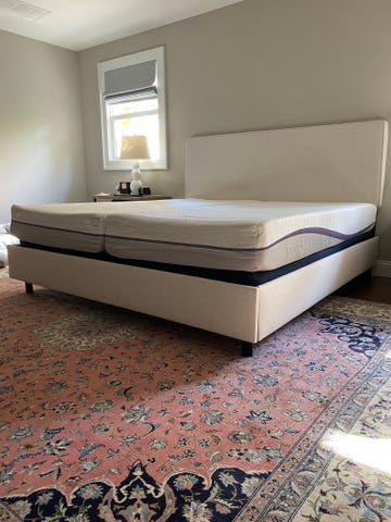 a white bed frame with a split king mattress in a bed room setting