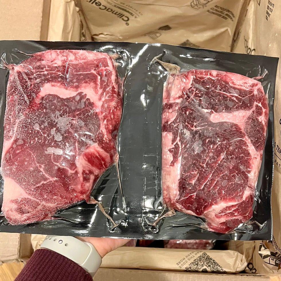 Sassos testing butcherbox, Two vacuumsealed cuts of meat held above an open cardboard box sassos testing butcherbox, two vacuumsealed cuts of meat held above an open cardboard box