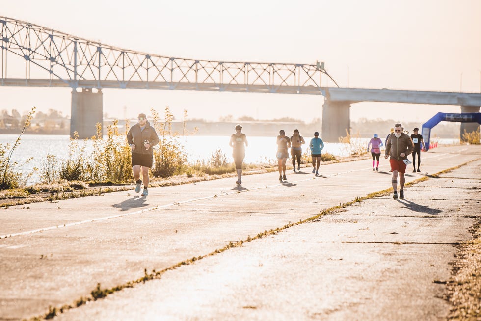 runners participating in a race along a river with a bridge in the background run the river in kennewick, wa