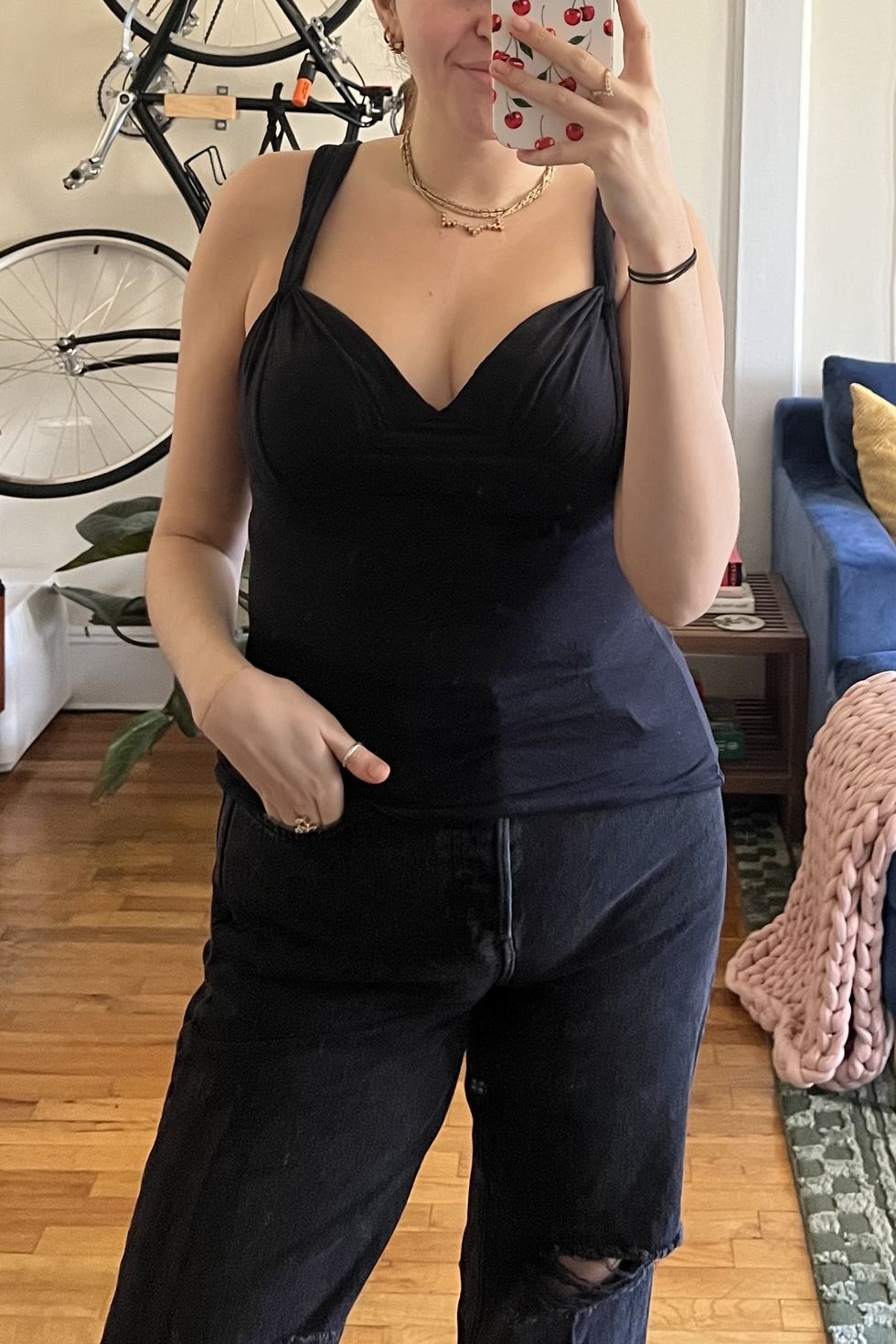 a woman taking a selfie with a black tank top while wearing the skims push up bra, skims review