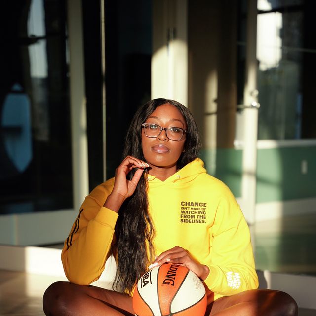 chiney ogwumike sits cross legged on the floor with a basketball in her lap