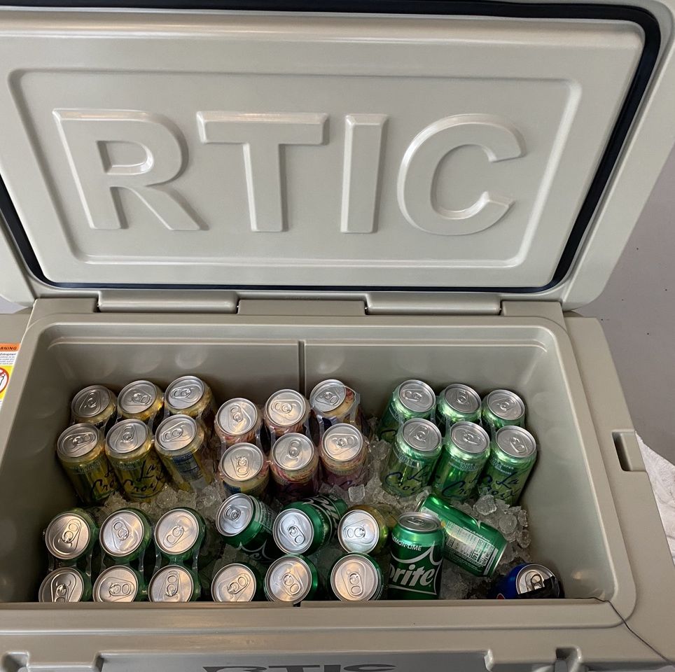a rtic cooler filled with ice and soda cans during testing