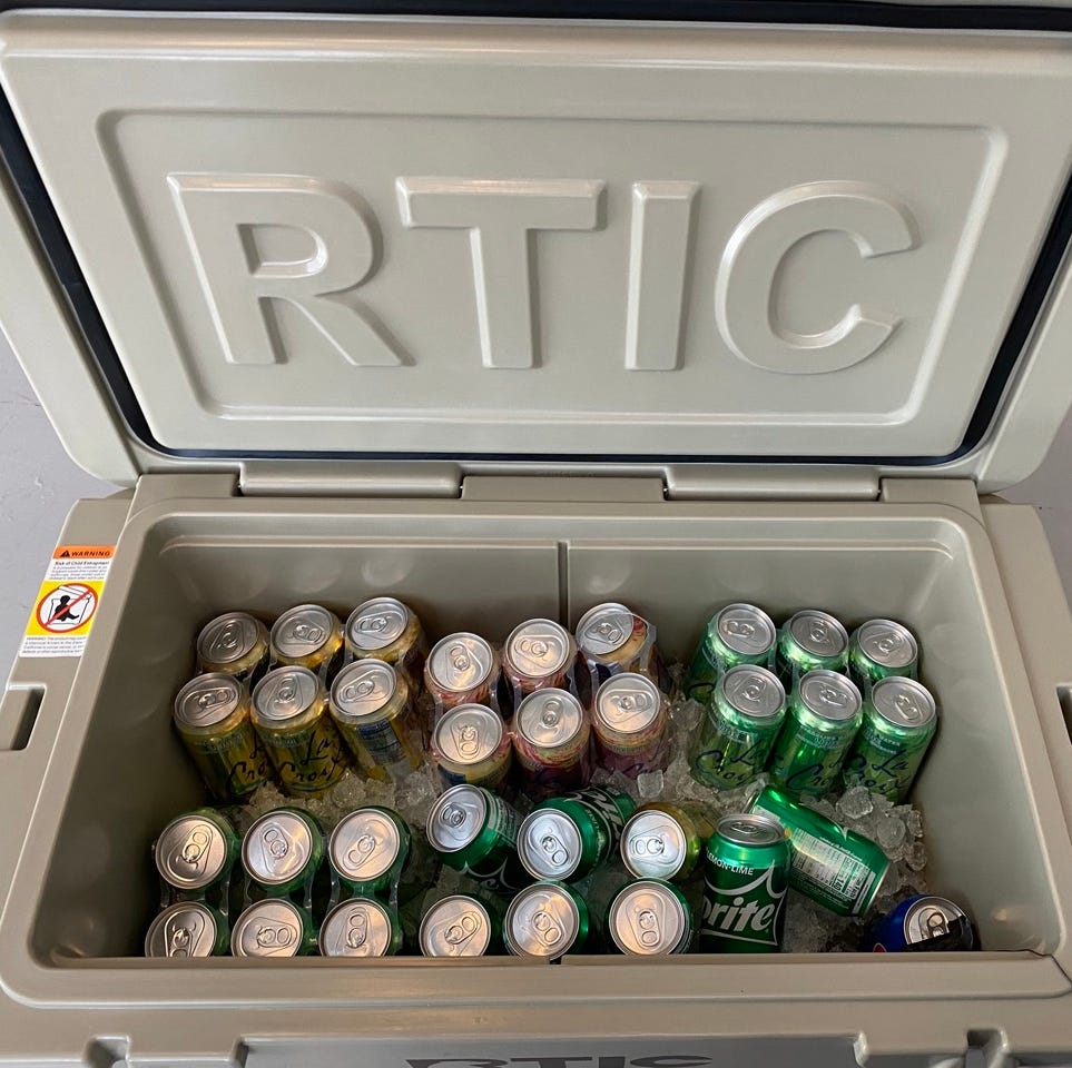 a rtic cooler filled with ice and soda cans during testing