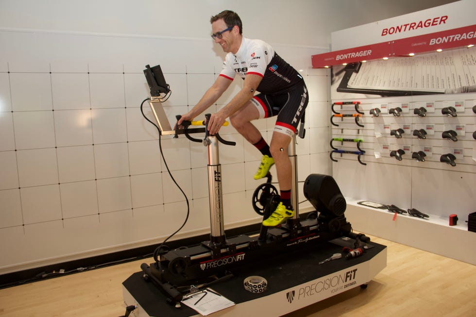 Cyclist using a specialized bike fitting machine in a shop environment