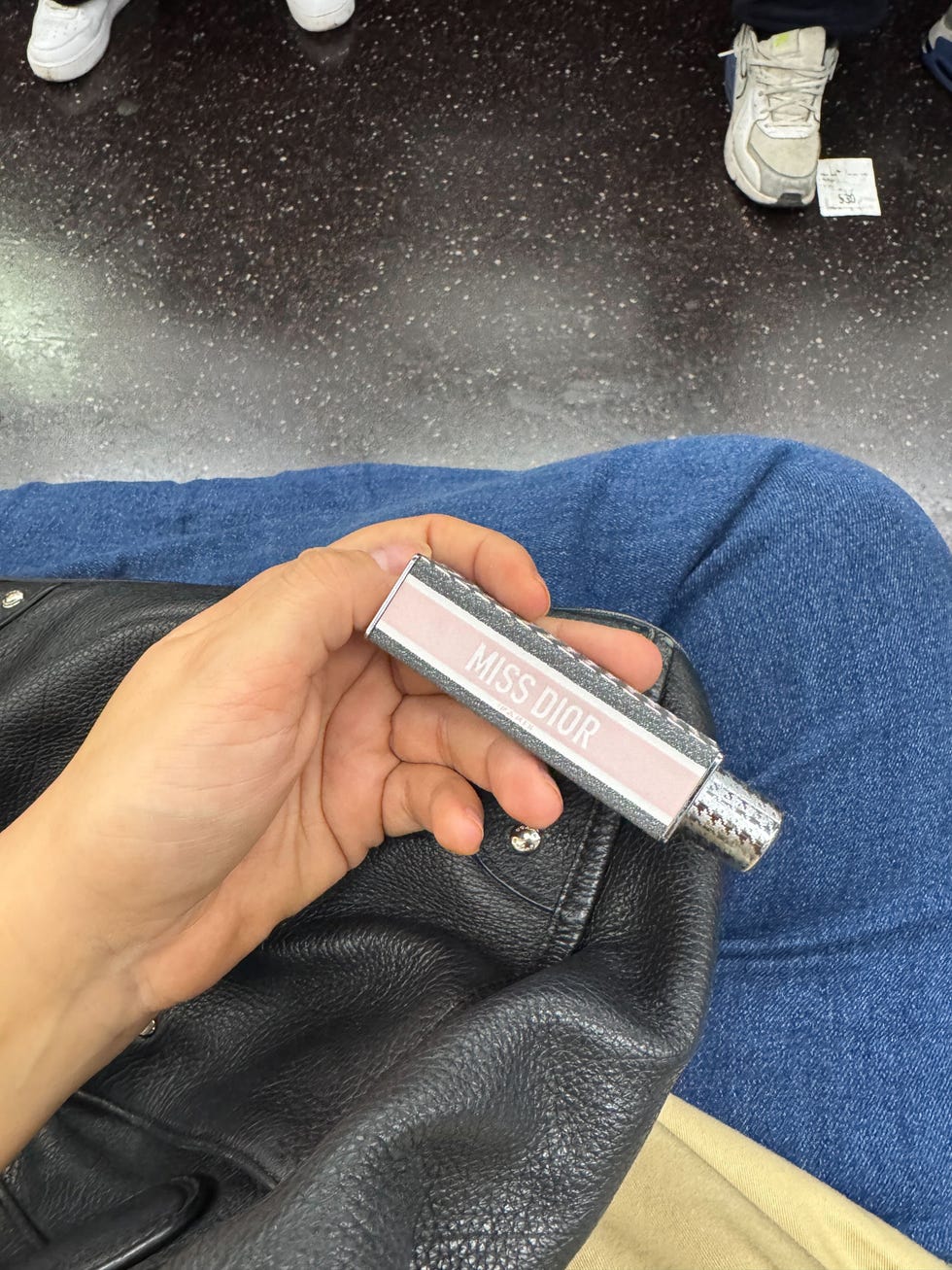 Garrafa de Miss Dior Perfume mantido em uma mão