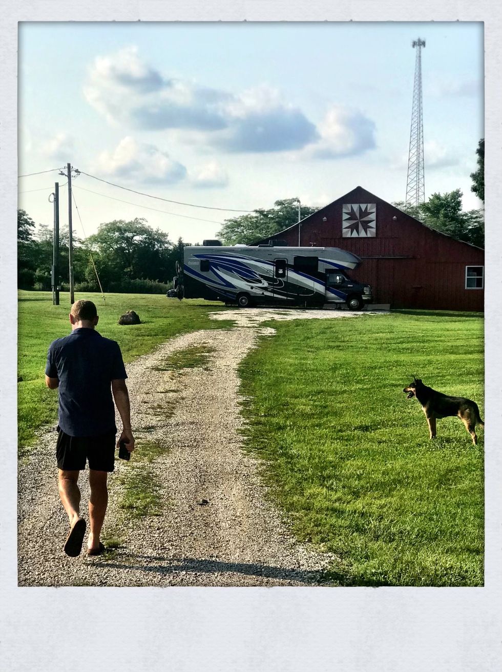 man and a dog with camper in background