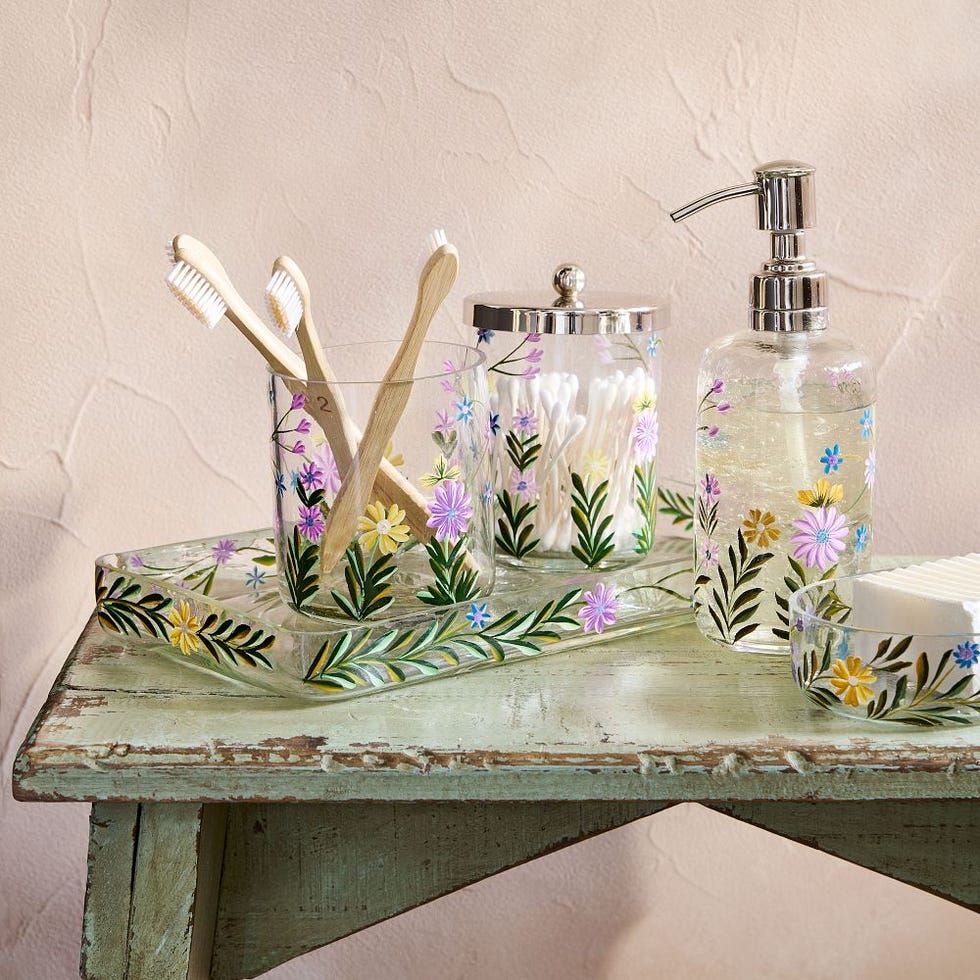 bathroom accessories containing toothbrushes cotton swabs and lotion with floral designs