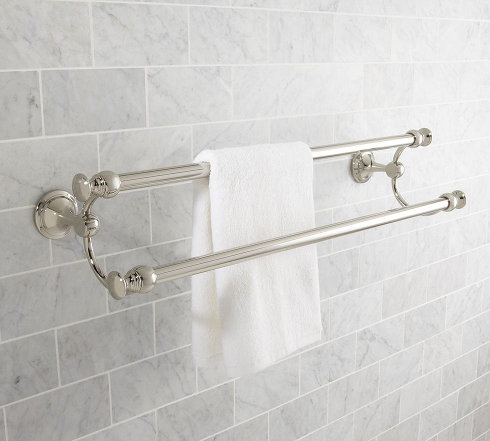 dual towel bar mounted on a tiled wall with a white towel hanging