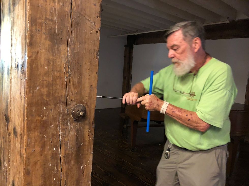 In het Terminal Warehouse neemt directeur Edward Cook van het Tree Ring Lab een houtmonster met de diameter van een rietje uit een oude houten staander