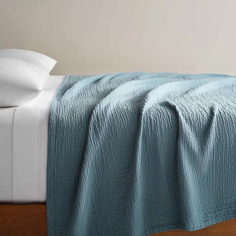 quilted blanket draped over a bed quilted blanket draped over a bed