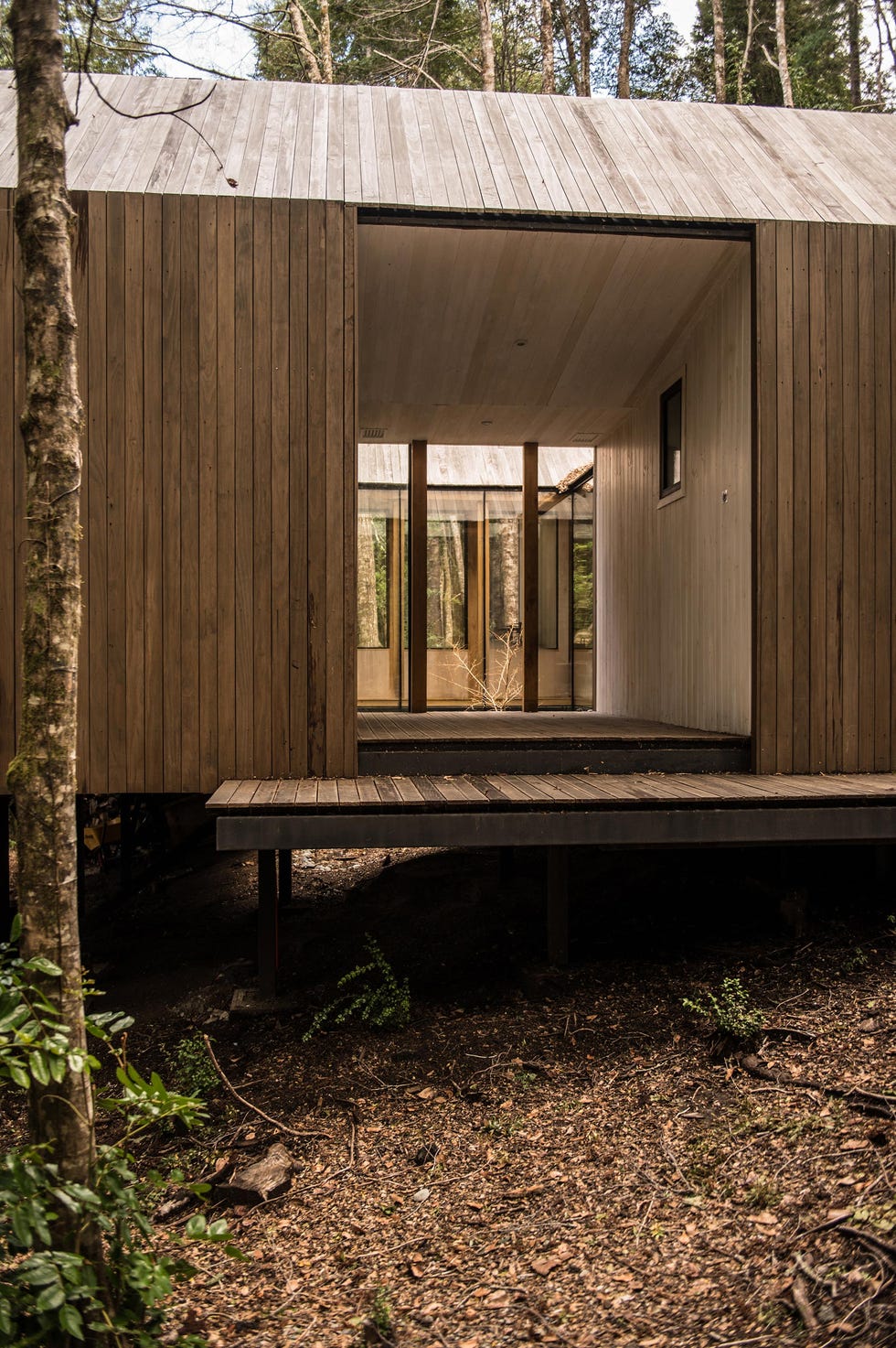 una cabana hecha de madera con un patio central que respeta la cordillera chilena y ademas es comoda y bonita