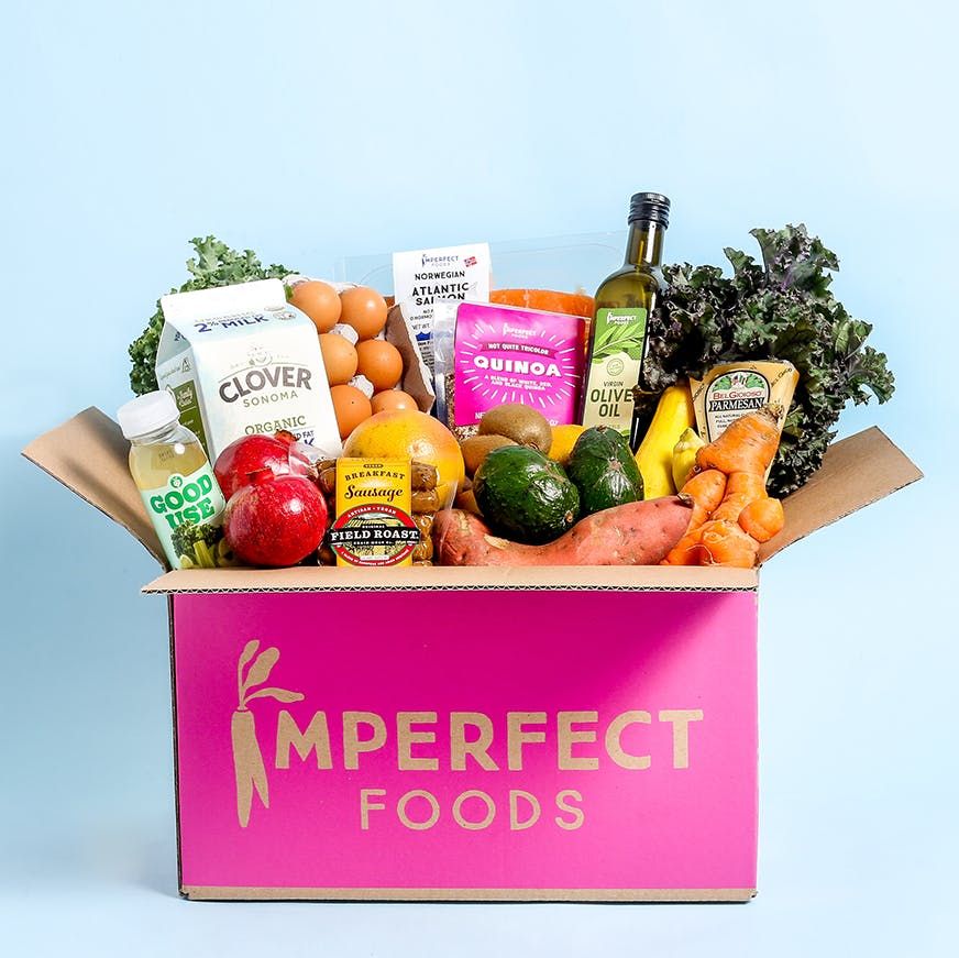 imperfect foods pink box with a variety of groceries on a blue background