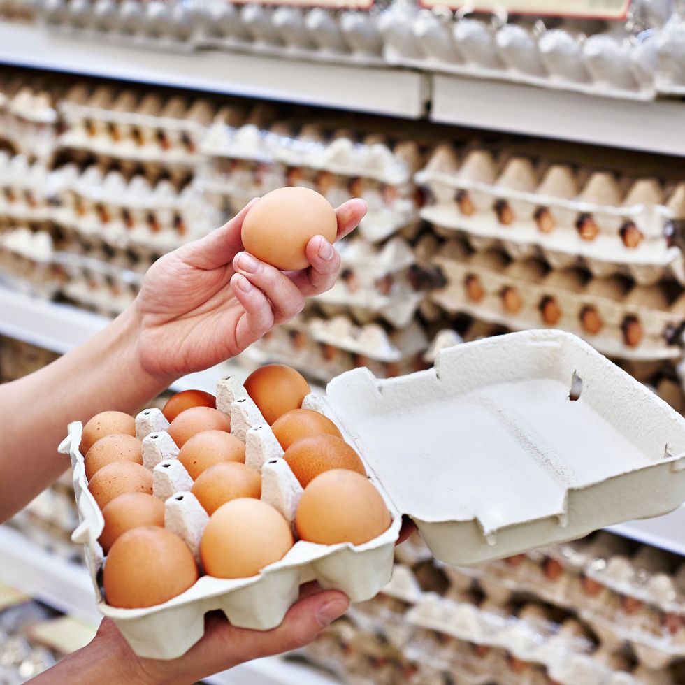 in hands of woman packing eggs in supermarket