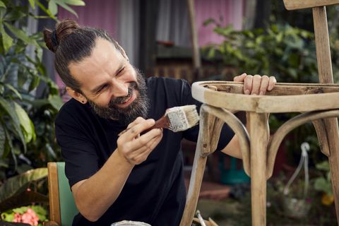 diy in the garden man painting wooden chair