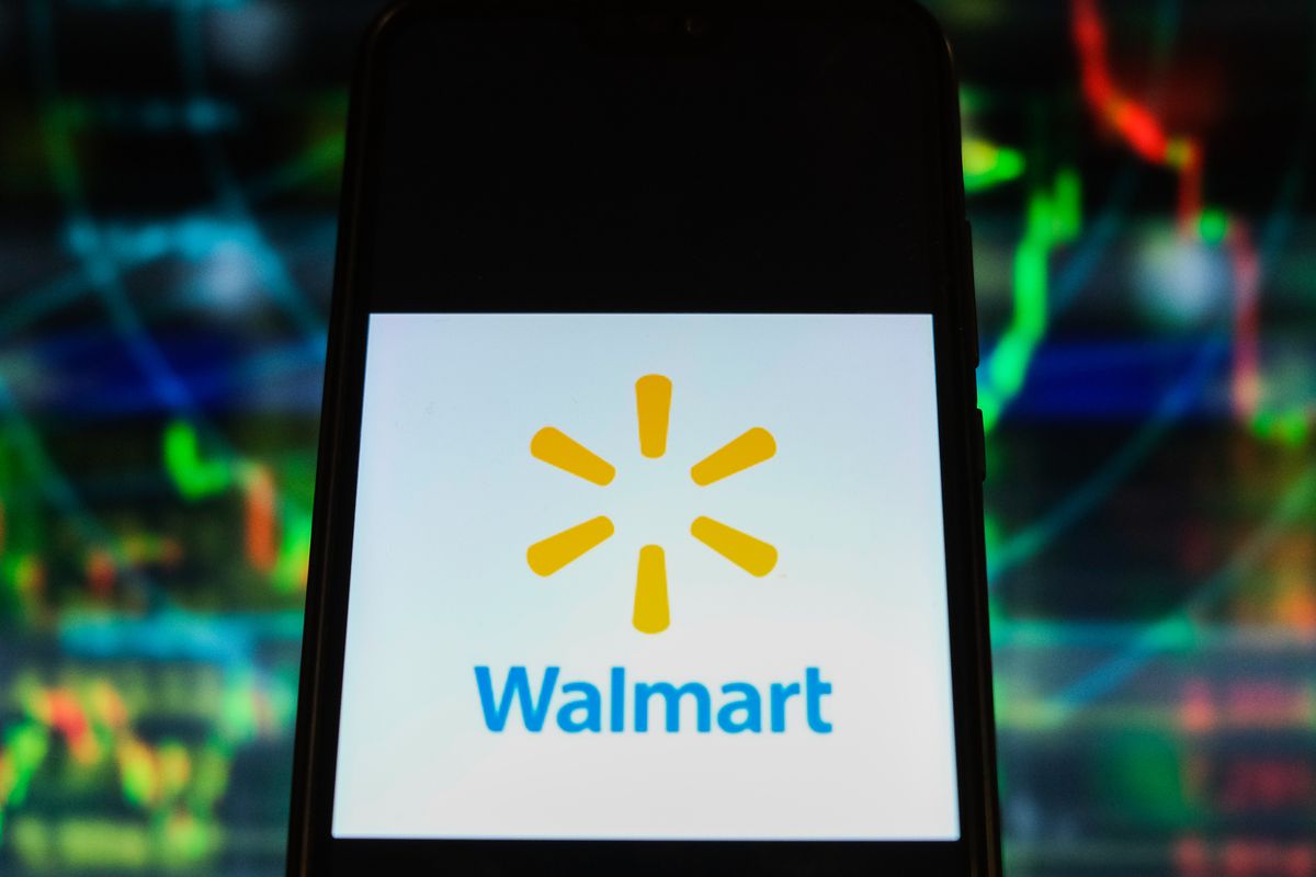 in this photo illustration a walmart logo is displayed on a