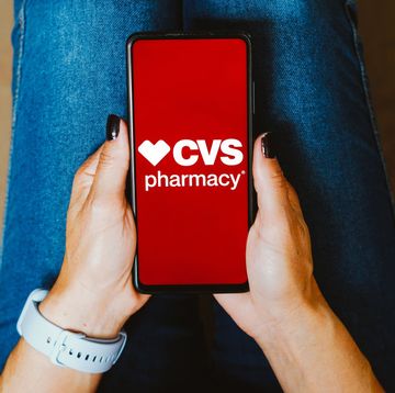 person holding smartphone displaying cvs pharmacy logo