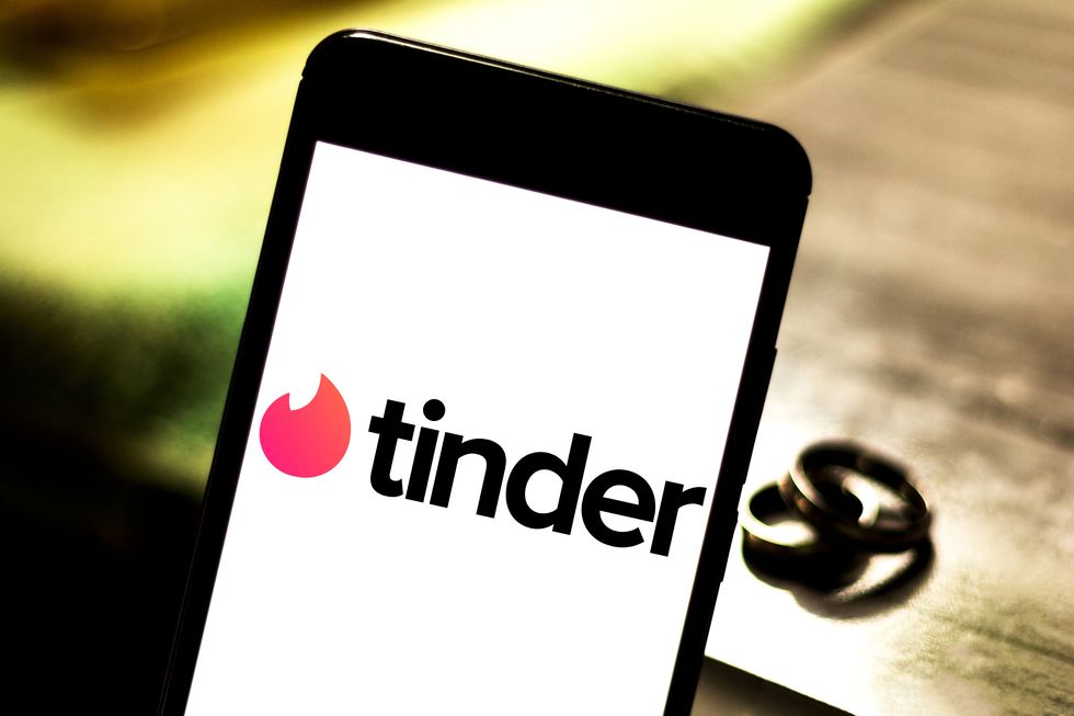 In this photo illustration Tinder logo seen displayed on a...