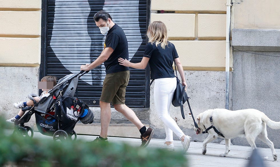 iñaki lópez y andrea ropero, con mascarillas, pasean con su hijo roke y su perro malo por las calles de madrid