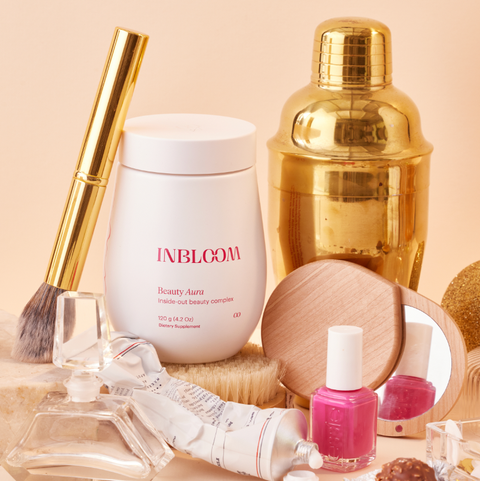 inbloom beauty aura powder on the table with other beauty products