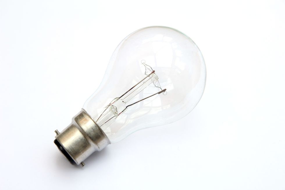 Incandescent tungsten clear B22 bayonet fitting light bulb isolated on white