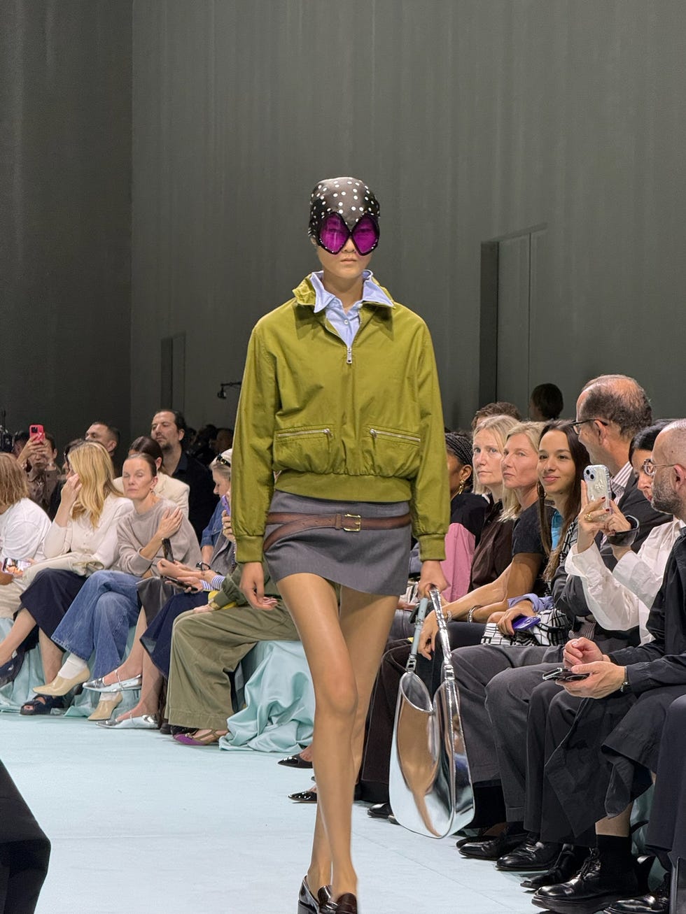 a model walks the runway in sunglasses and bandana at prada's spring 2025 show