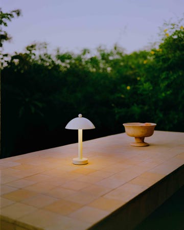 a bell shaped portable lamp on a table outside