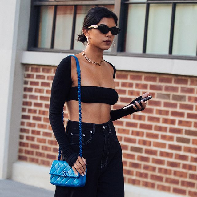 a woman walks at fashion week wearing a bandeau bra in a roundup of the best bandeau bras 2022