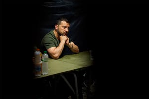 a zelebsky sitting at a table with a drink and bottles of water