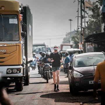 Will Robinson runs across India a person running on a busy street in india amidst vehicles