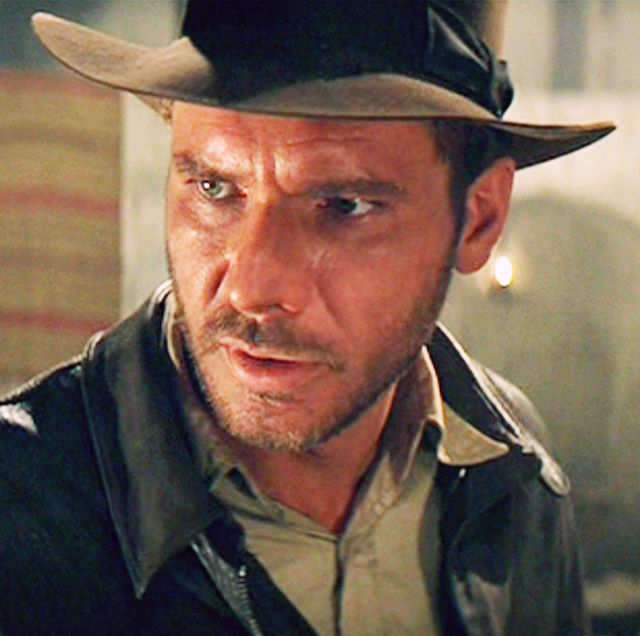 harrison ford wearing a hat and looking off camera while portraying indiana jones