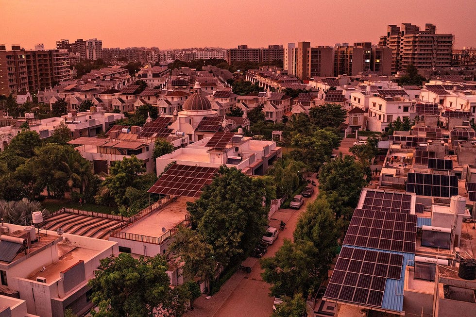 In Nikol een welvarende buurt in Ahmedabad de grootste stad van Gujarat vangen zonnepalen op huizen en flatgebouwen de laatste zonnestralen van de dag op Steeds meer Indirs verhuizen van het platteland naar de stad en maken gebruik van de zon om elektriciteit op te wekken