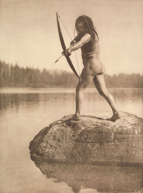 Een lid citizen van de Nuuchahnulth Nation die voorheen bekendstond als de Nootka Nation richt met zijn pijl en boog op het water