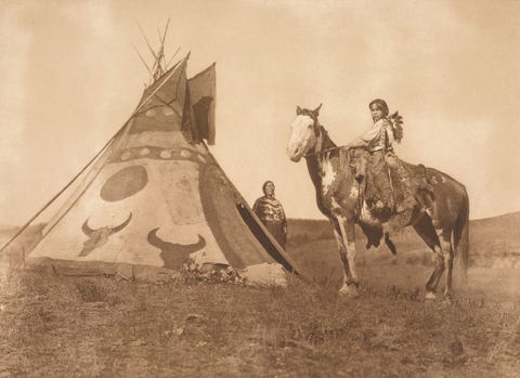 Een Assiniboinekind zit op een paard