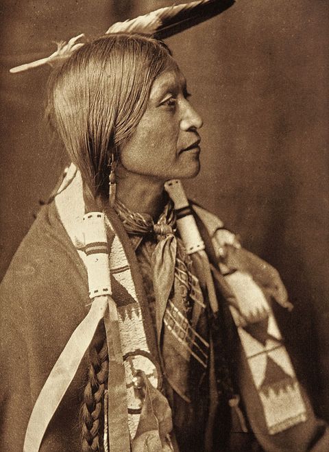 Een lid citizen van de Jicarilla Apache Nation poseert voor een tintypefoto voor fotograaf Edward S Curtis in het begin van de twintigste eeuw Curtis werd bekend om zijn werk over het Westen van Amerika en over inheemse Amerikaanse gemeenschappen