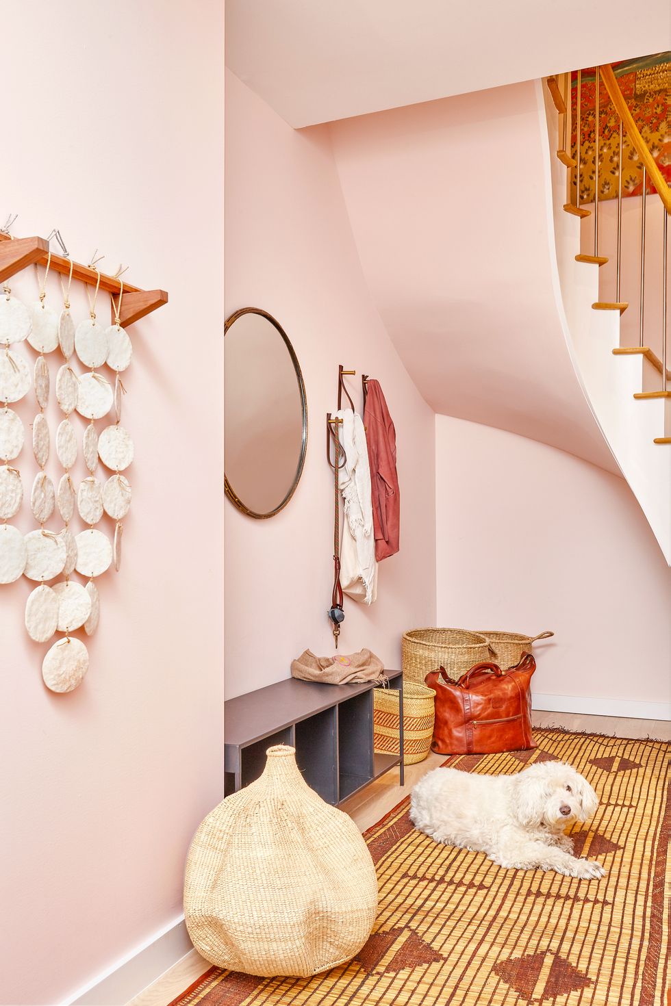 entryway with light pink paint and boho decor